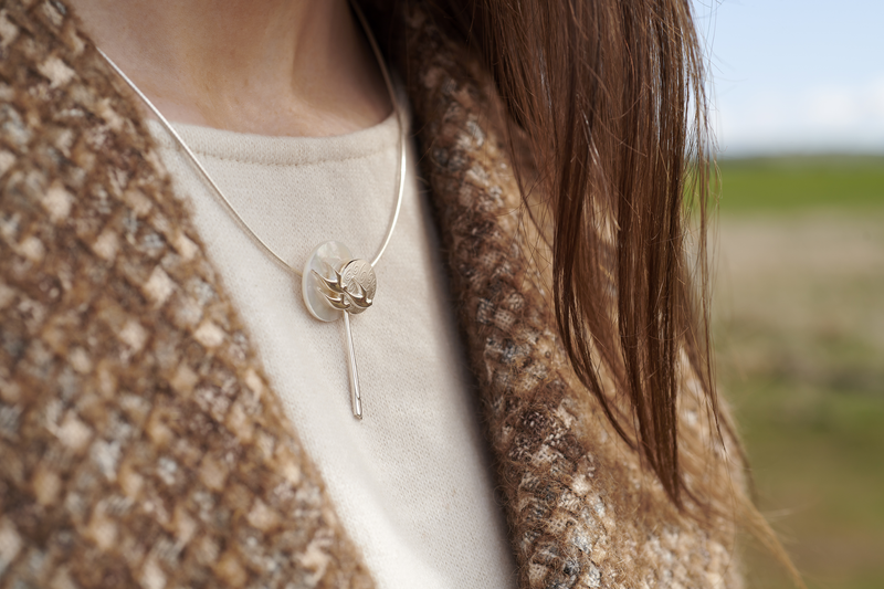 close up of woman in field wearing birdland necklace