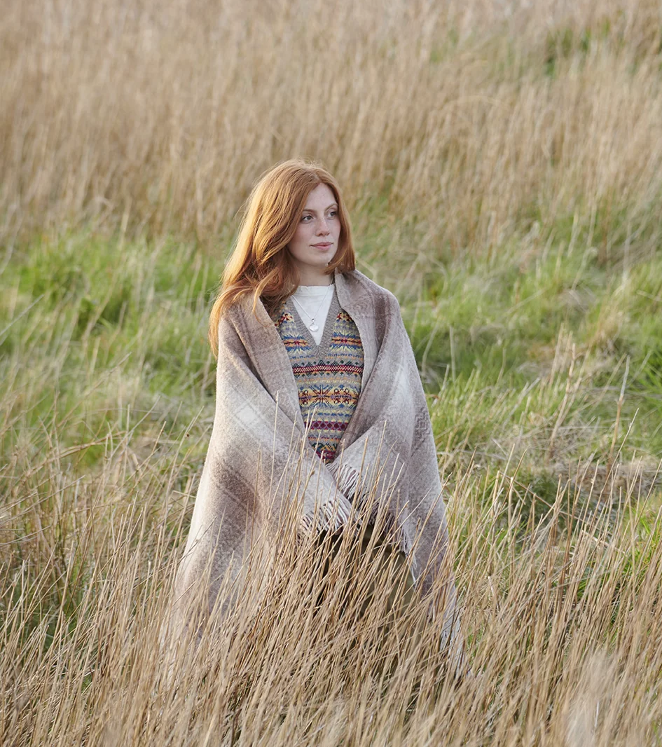 woman with shawl walking through long grass