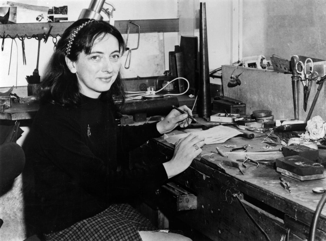 black and white image of Ola as a young woman sitting at the workbench