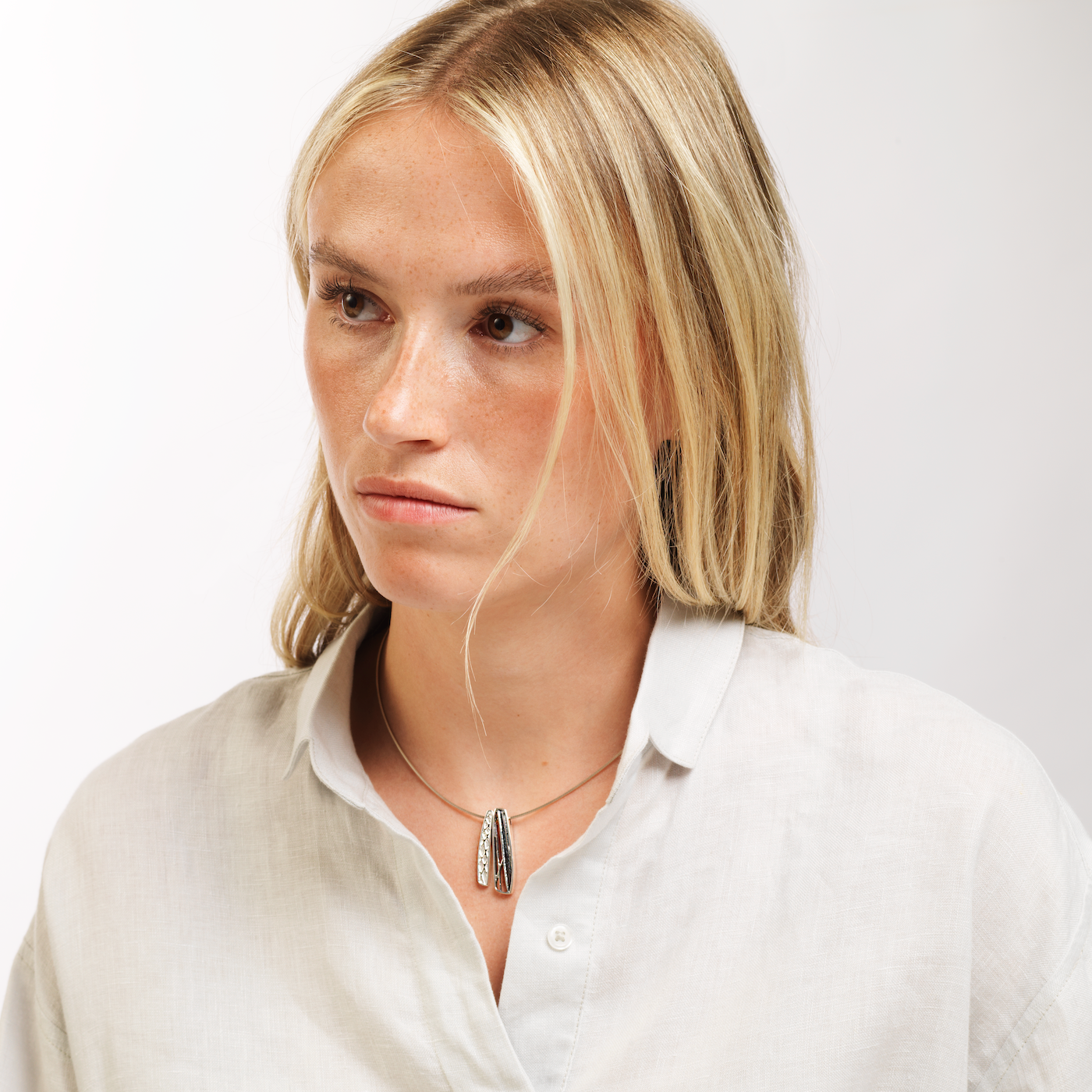 Woman in white shirt wearing ness of brodgar necklace