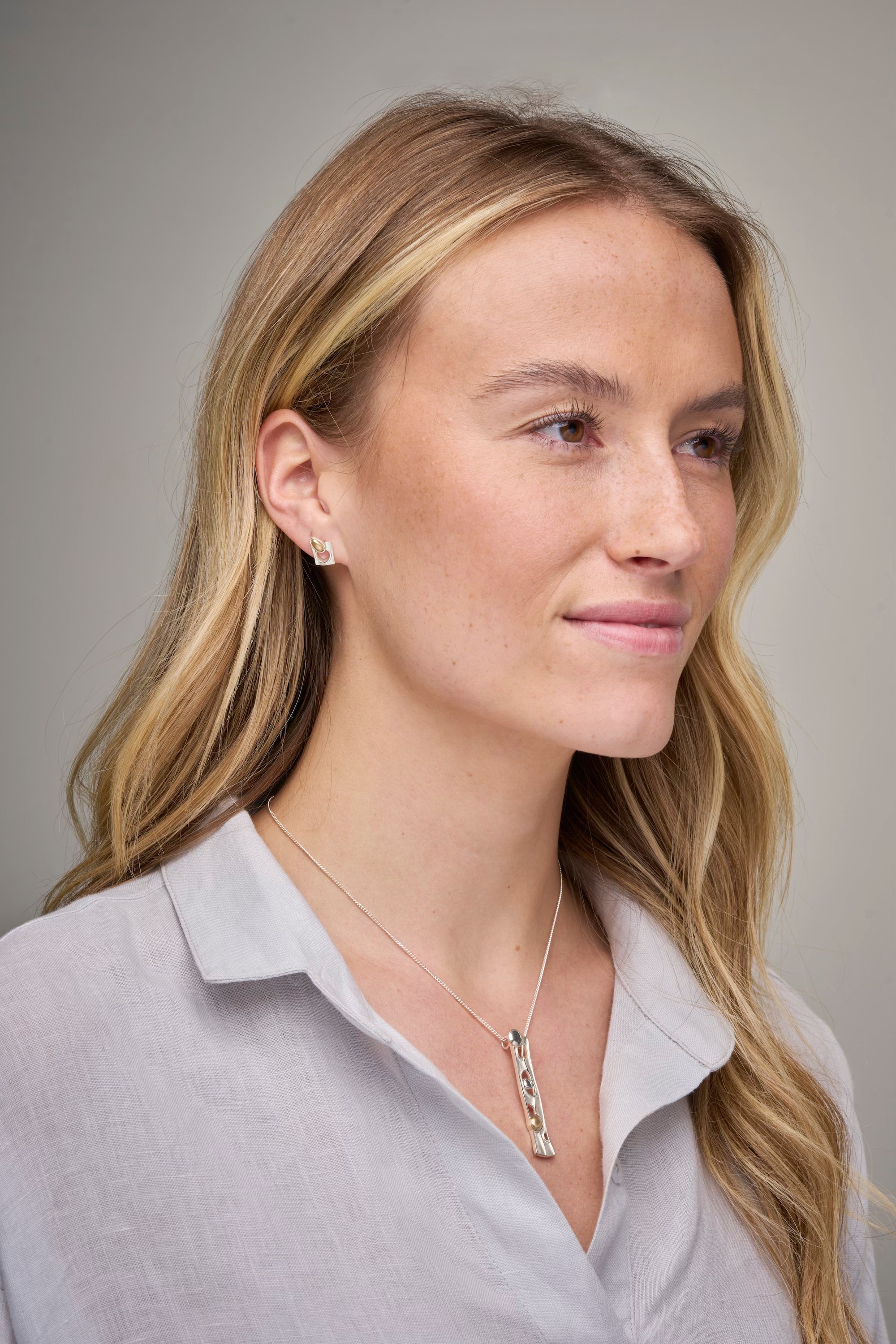 Woman in grey top with necklace