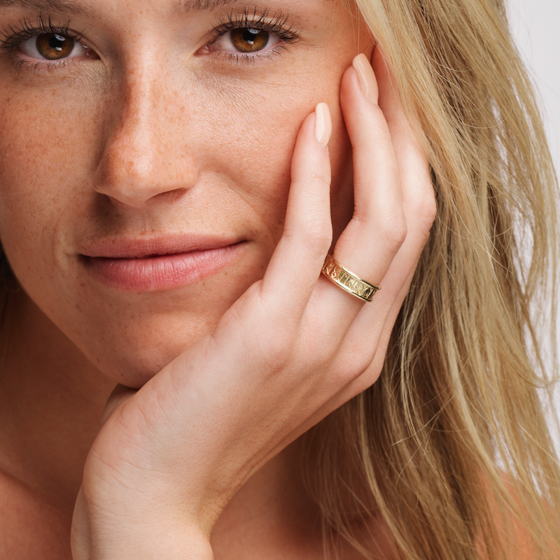 Blonde haired woman wearing Ola Gorie Runic 'I Love You' ring in gold