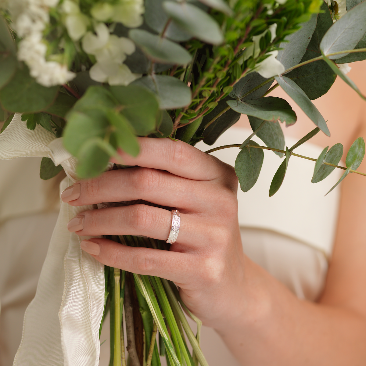 Woman holding bouquet with ring in focus