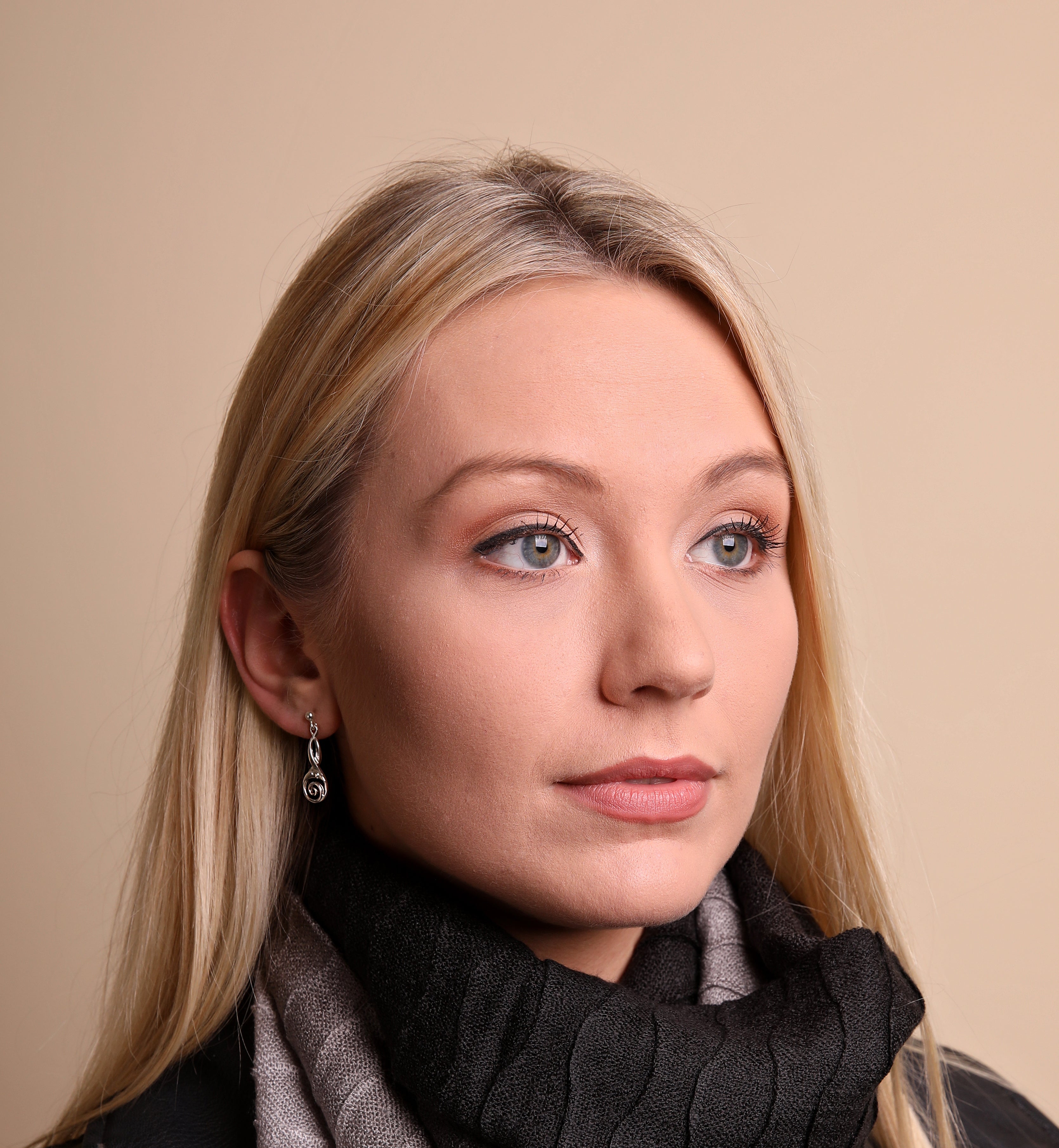 Woman in black top models silver drop earring from the Kells Bird Collection