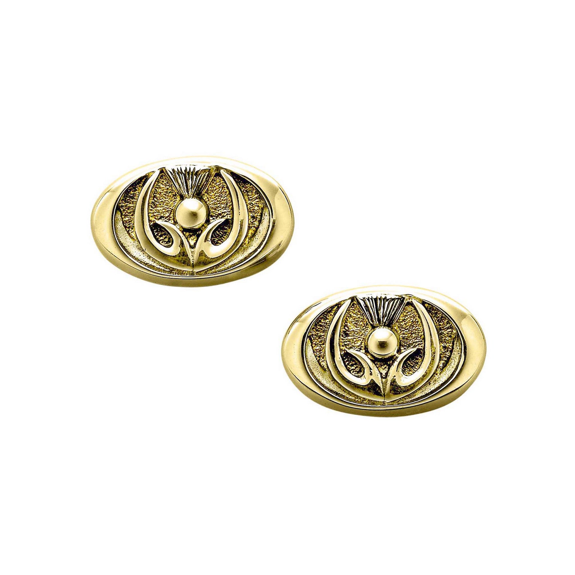 A pair of oval gold cuff links with a inner thistle design