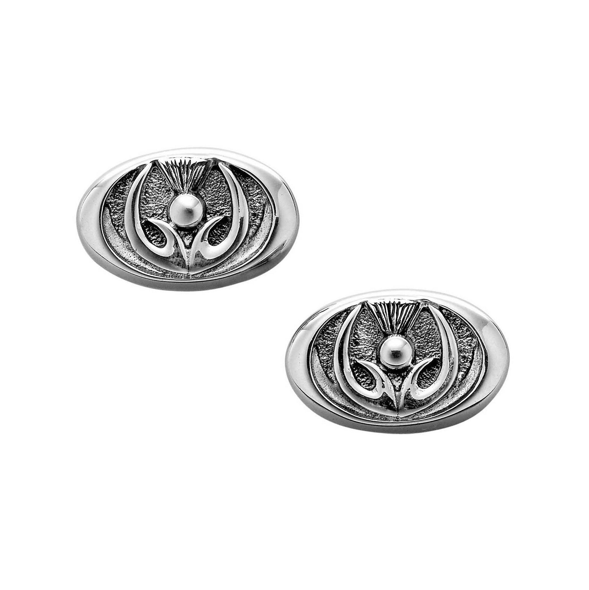 A pair of oval silver cuff links with a inner thistle design