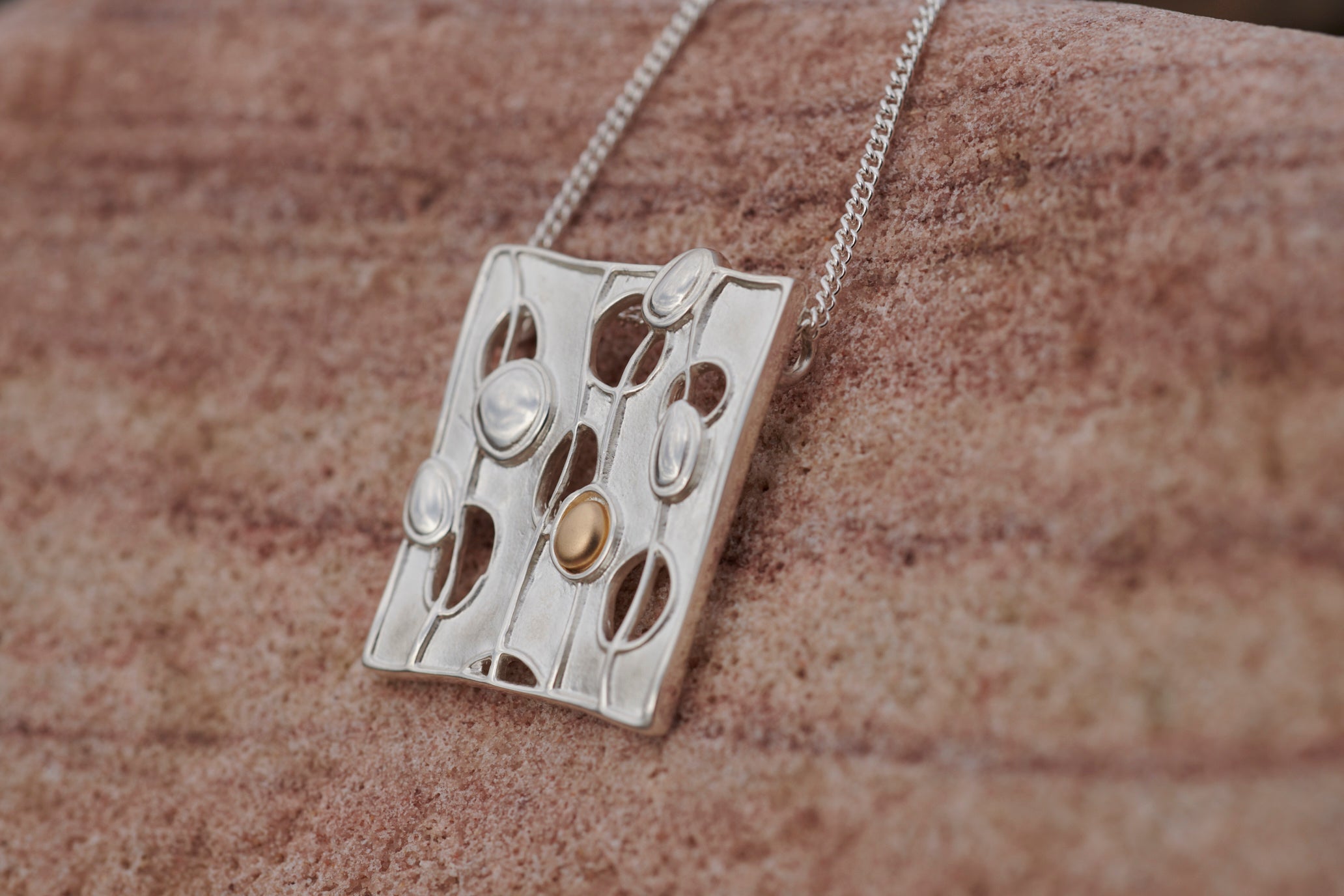 Close up of a silver Flow pendant