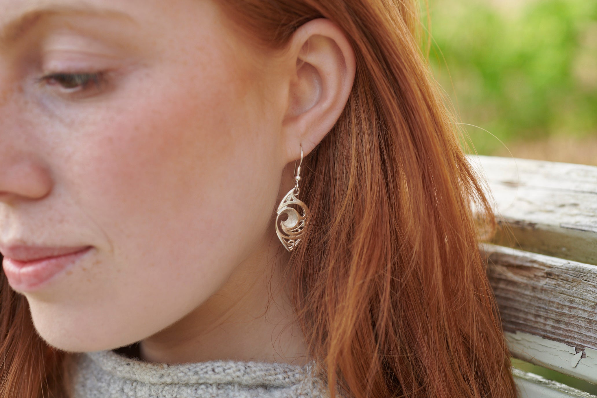 Close up of woman wearing silver Evie earring
