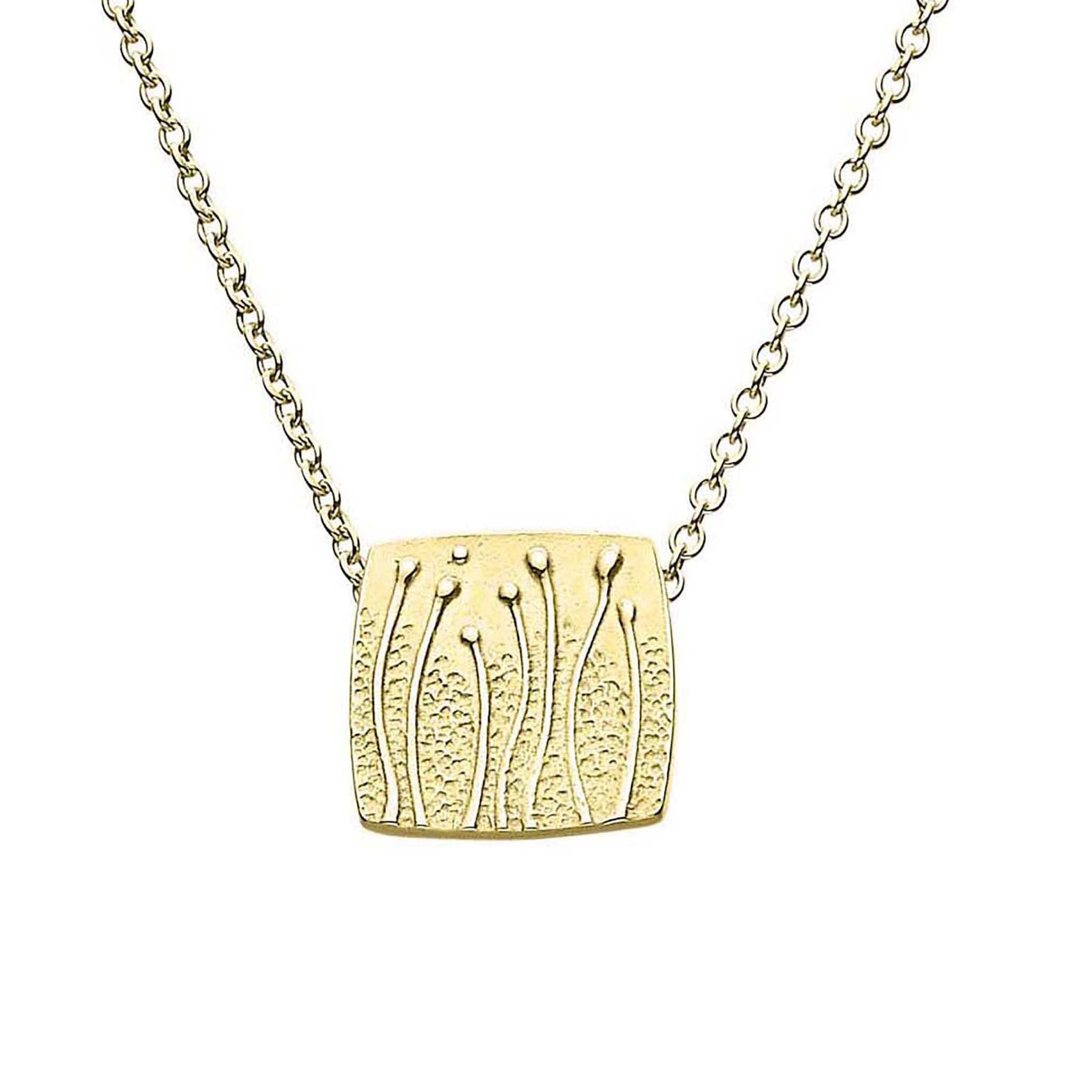 A gold necklace featuring a small rectangular pendant with a floral pattern, displayed against a white background.