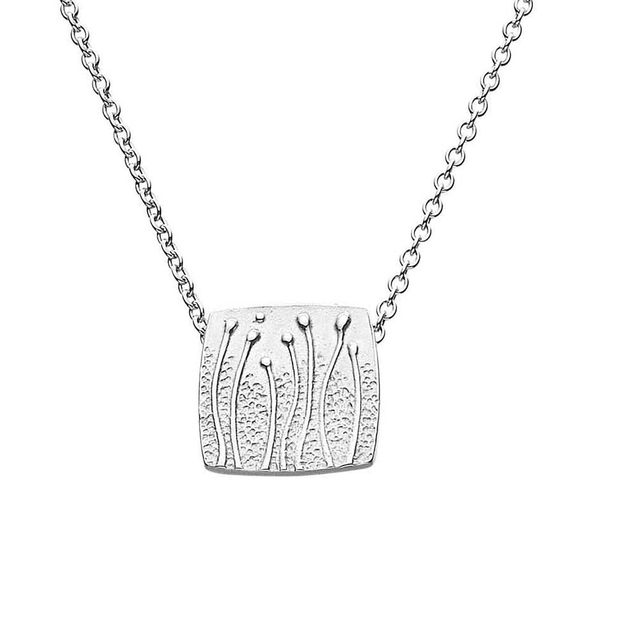 A silver necklace featuring a small rectangular pendant with a floral pattern, displayed against a white background.