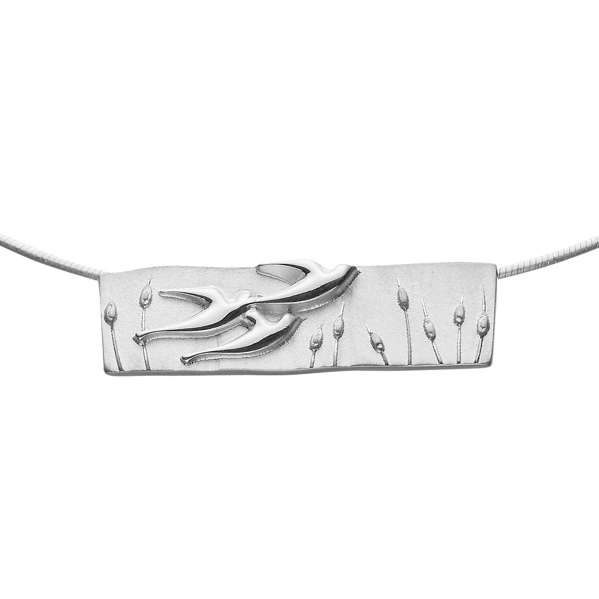A silver necklace with a rectangular pendant featuring a bird in flight surrounded by floral designs.