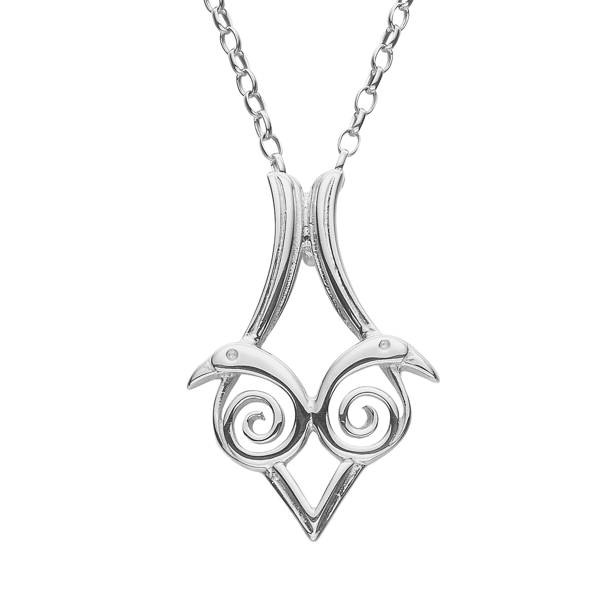 A silver pendant necklace featuring a stylized bird design, inspired by the Book of Kells.