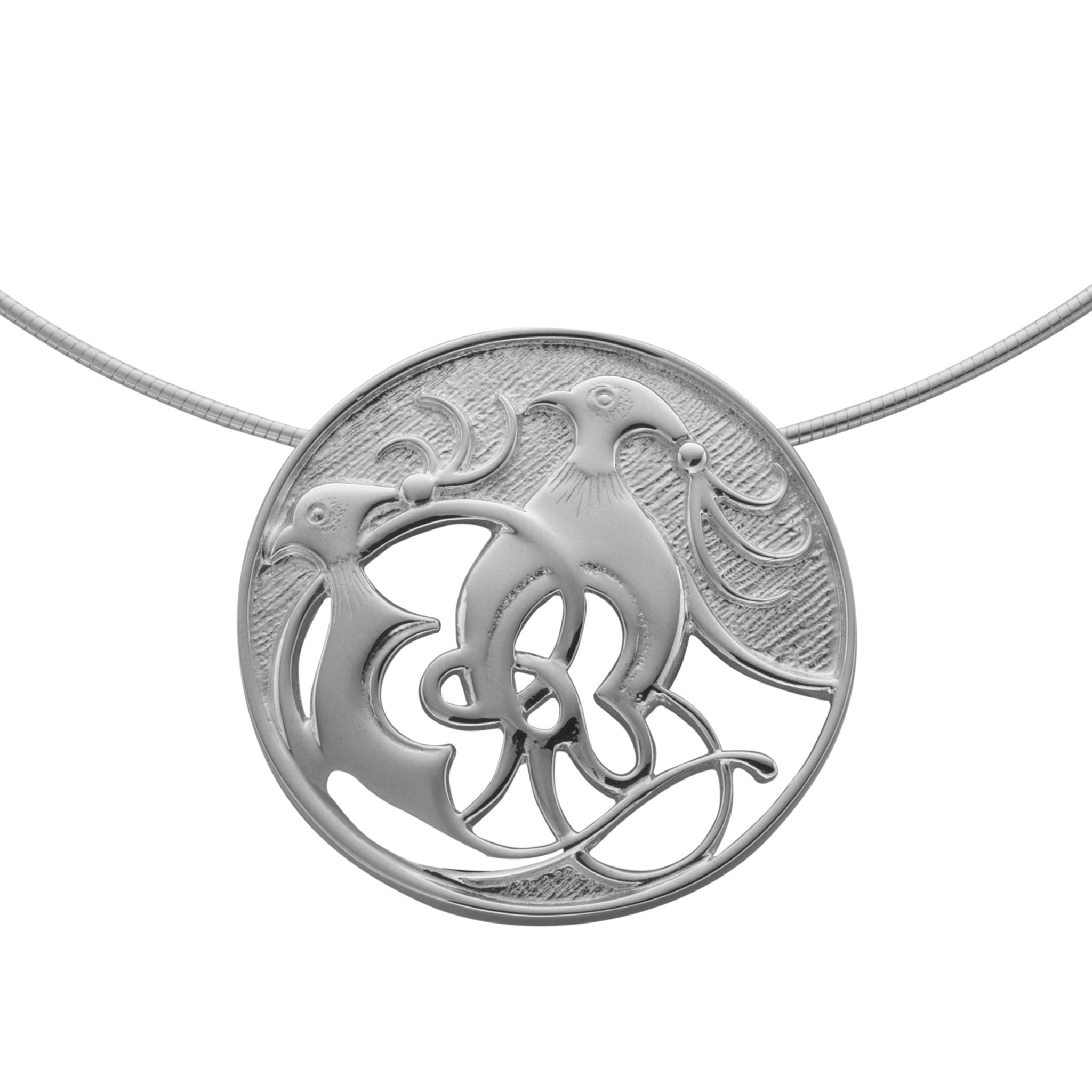 A silver circular pendant with intricate design of two birds
