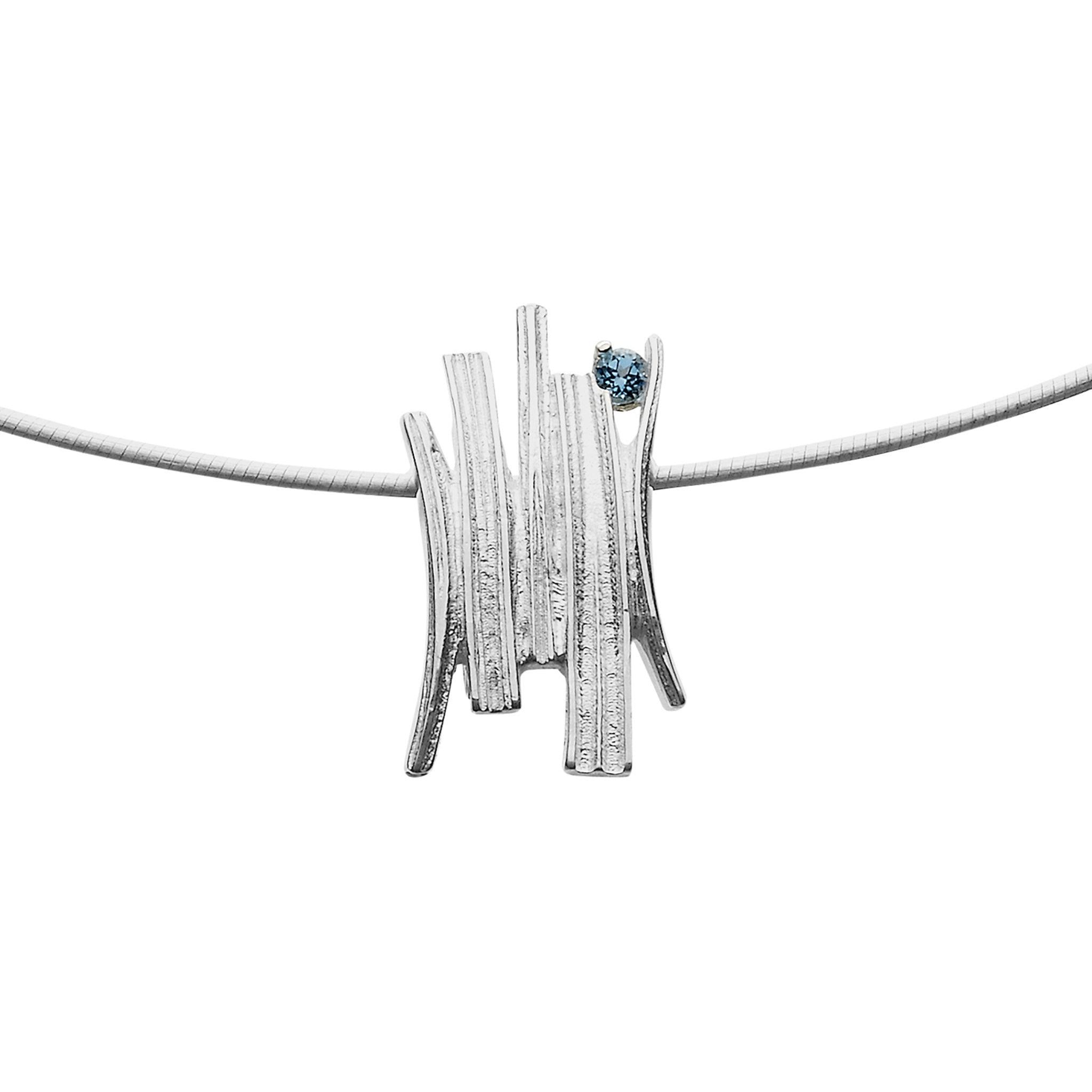 A silver necklace with a pendant that has a grass like design finished with a blue gem stone