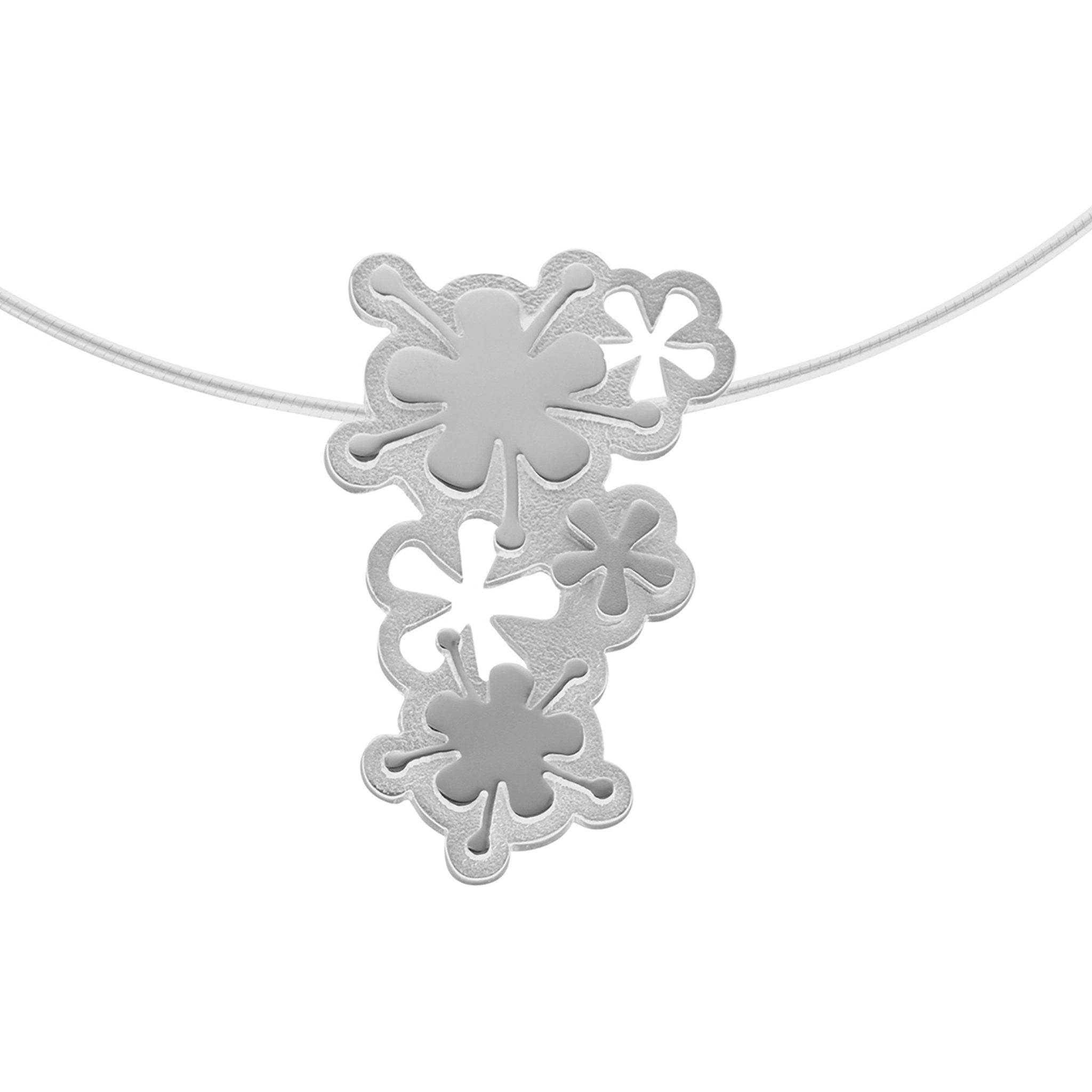 A silver necklace with a delicate pendant that has a flower and petals design